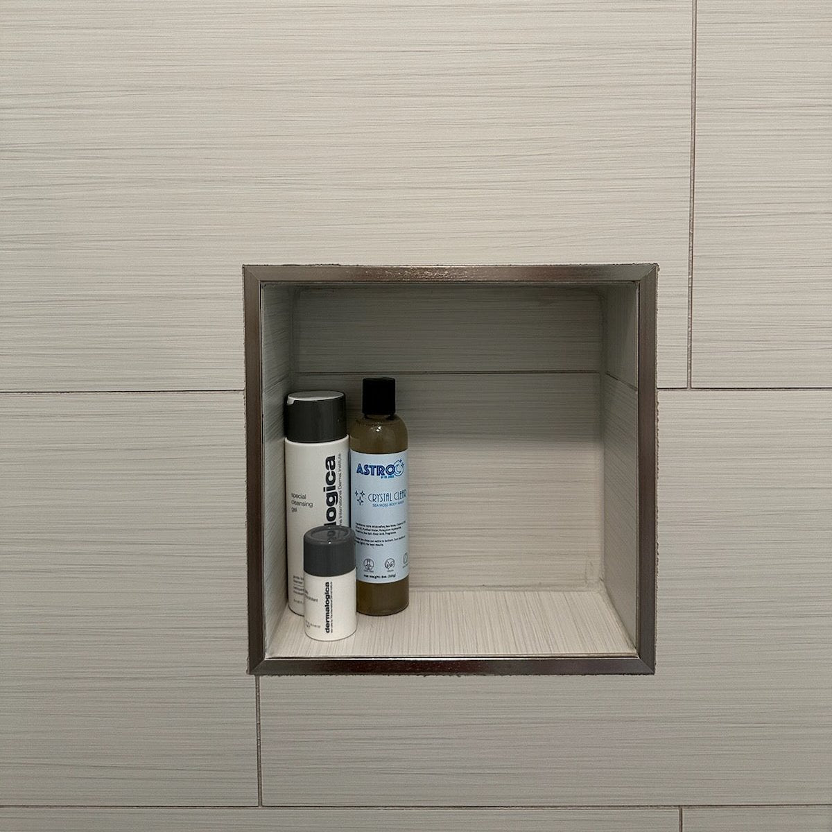 Astro Sea Moss Body Wash bottle in bathroom wall niche with other skincare products