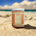 Astro Brand Solar Strength gold sea moss gel in a clear jar on sandy beach background.