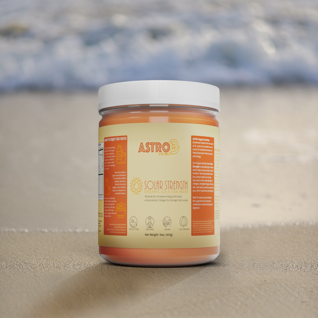 Astro Brand Solar Strength gold sea moss gel in a clear jar with a white lid, set against a blurred beach background.